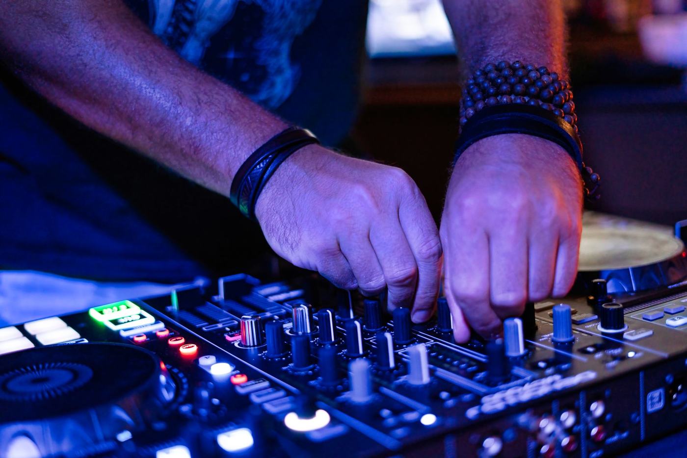 DJ hands mixing on a club console